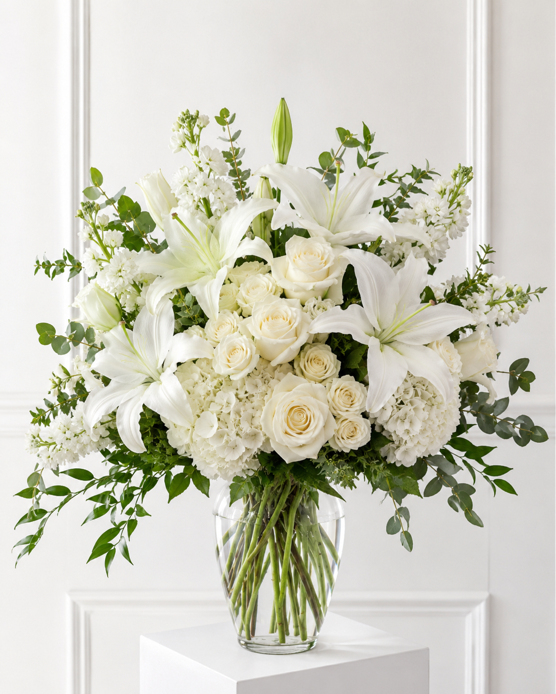 Graceful White Garden Vase with white lilies, roses, hydrangeas, and seasonal flowers in a clear glass vase by Flowers Shop Edmonton.